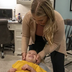 Dr. DoniBeth Davis doing chiropractic technique in a smiling infant